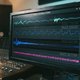 A close-up shot of the Oszillos Mega Scope plugin interface displayed on a studio monitor, showing two distinct waveforms (one for kick drum, one for bass guitar) overlaid or side-by-side, clearly illustrating their phase relationship and interactions. Th